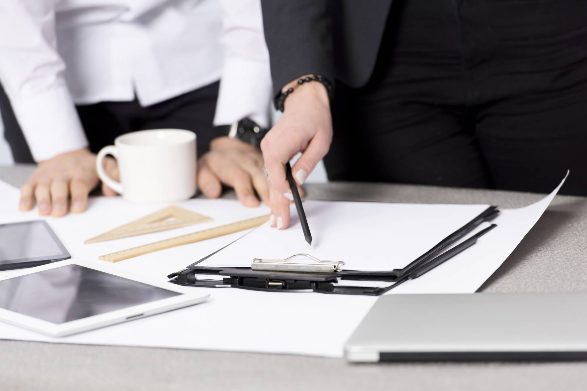 close-up-businesswoman-s-hand-holding-pencil-paper-clipboard-desk_1900x1268